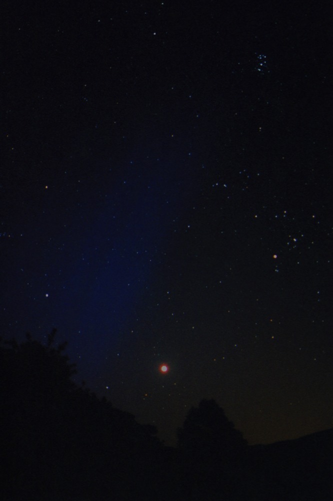 Faint blue auroral rays appear over the eastern horizon on July 27, 2004